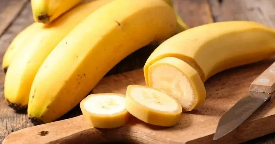 Banany na desce do krojenia. W całości i pokrojone w plasterki.