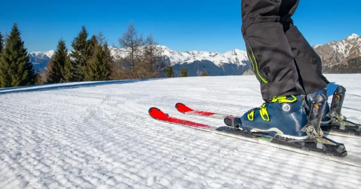 Na dobrze przygotowanym stoku narciarskim nogi narciarza zjeżdzającego w dół