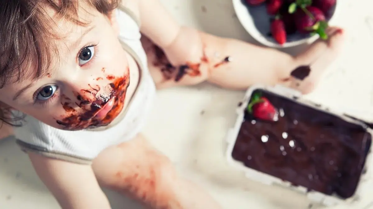 Małe, brudne dziecko je czekoladę.