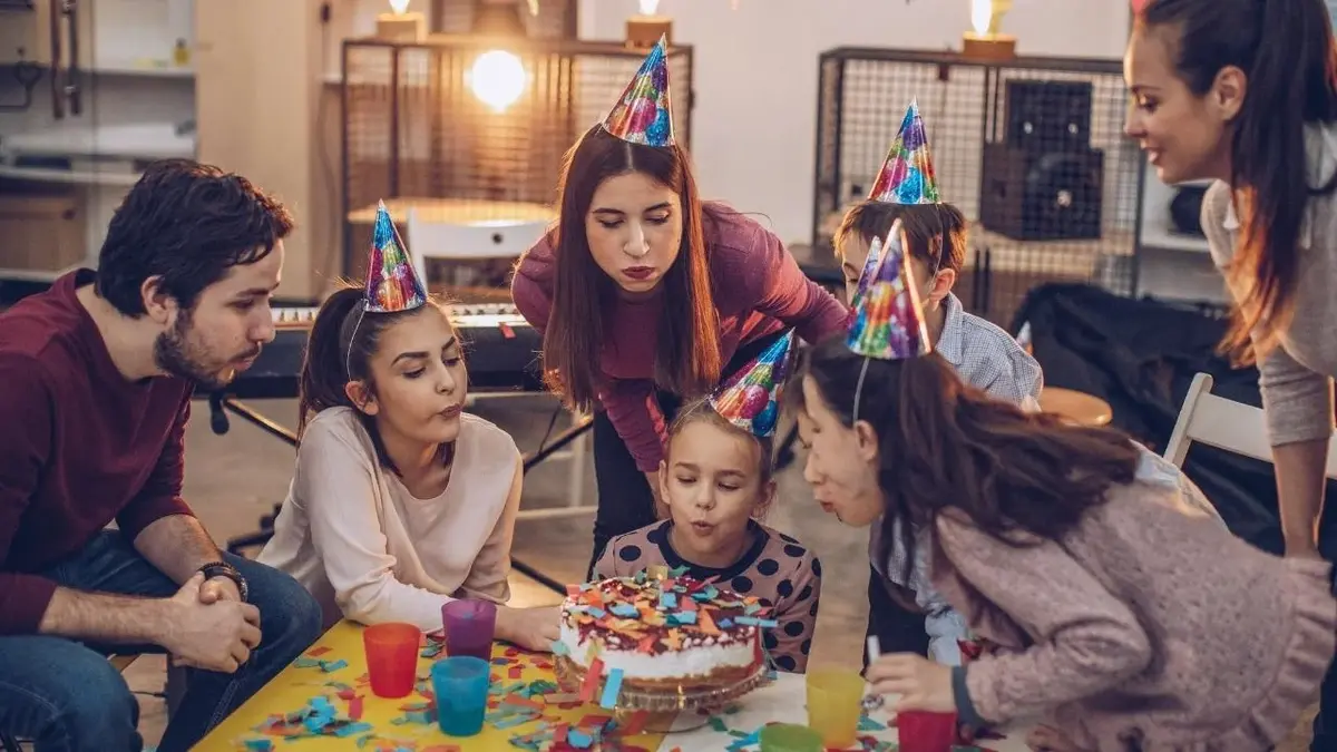 Rodzina bierze udział w przyjęciu urodzinowym dziecka.