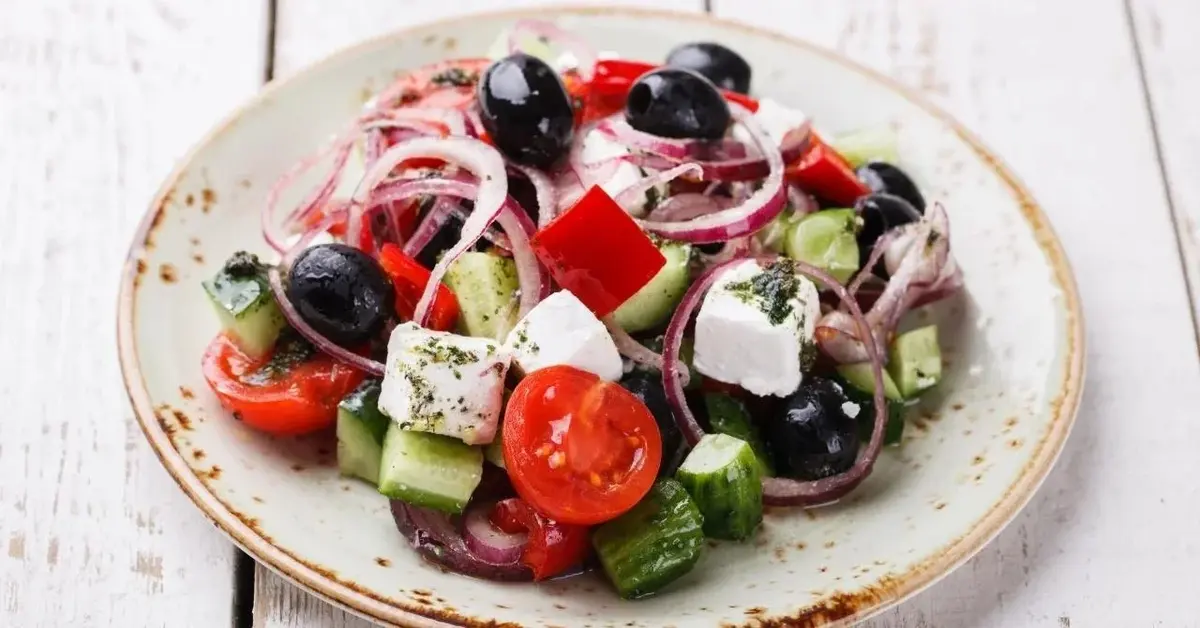 Sałatka grecka z czerwoną cebulą, pomidorkami, oliwkami i ogórkiem.