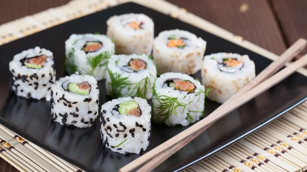 Uramaki sushi na desce do podawania sushi