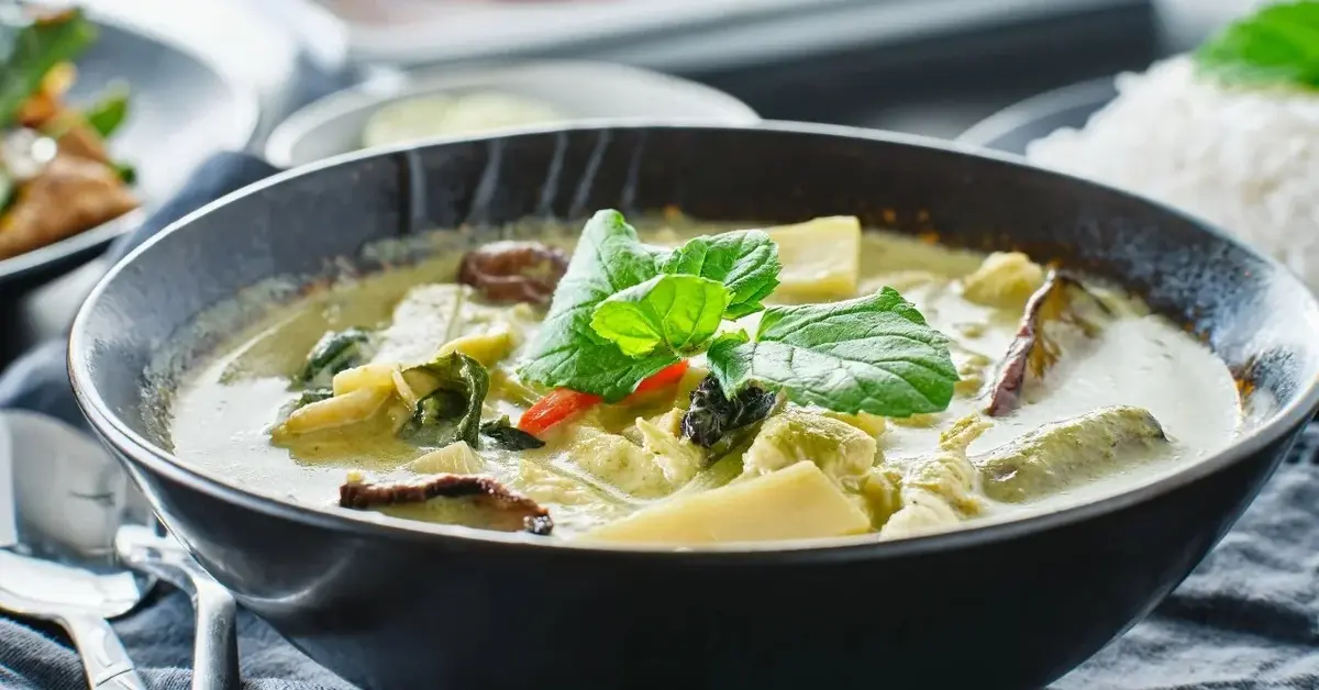 Zielone curry warzywne w czarnym głębokim talerzu