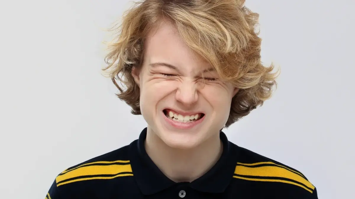 Chłopak z zaciśniętymi zębami