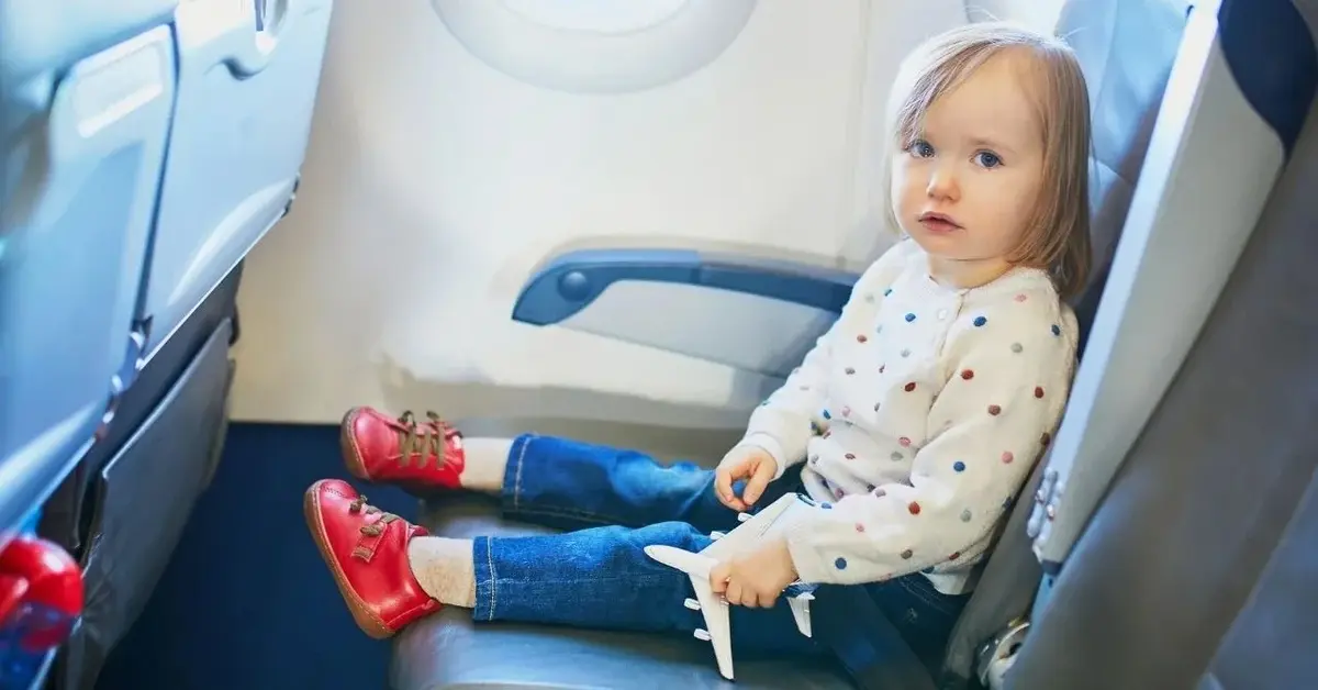 Dziewczynka siedzi na miejscu przy oknie w samolocie