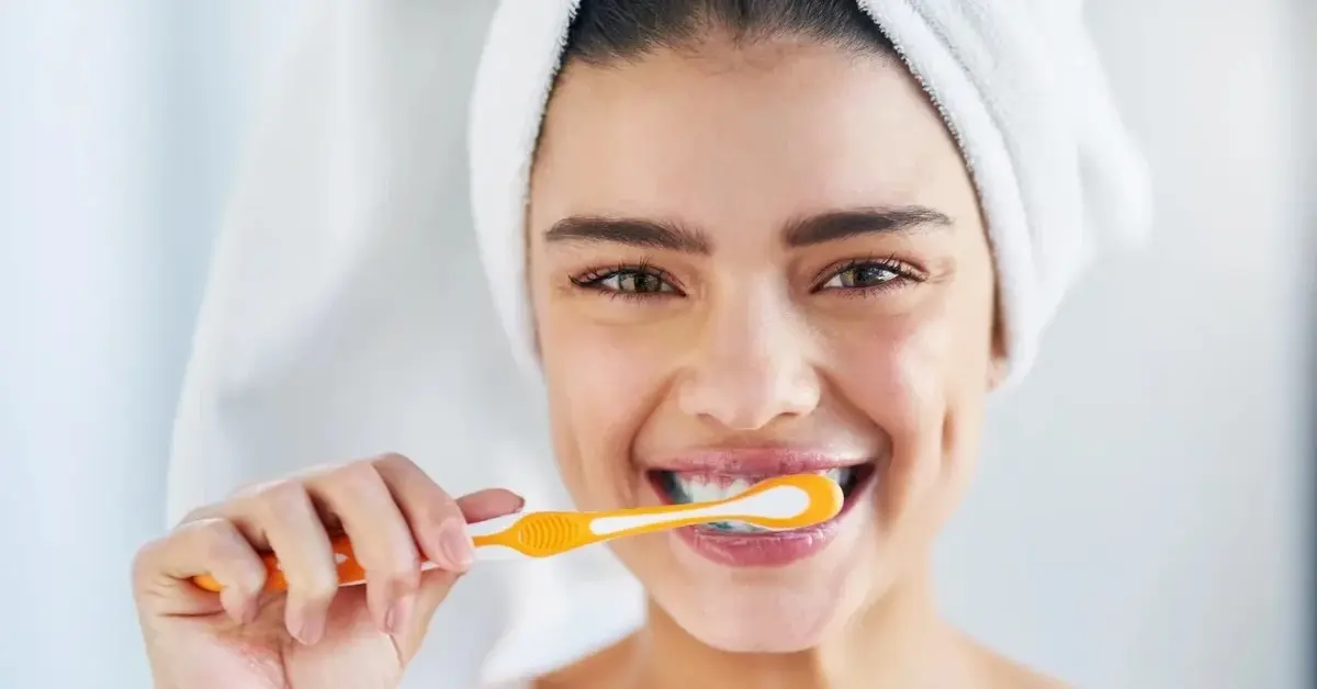 Kobieta myjąca zęby żółtą szczoteczka 