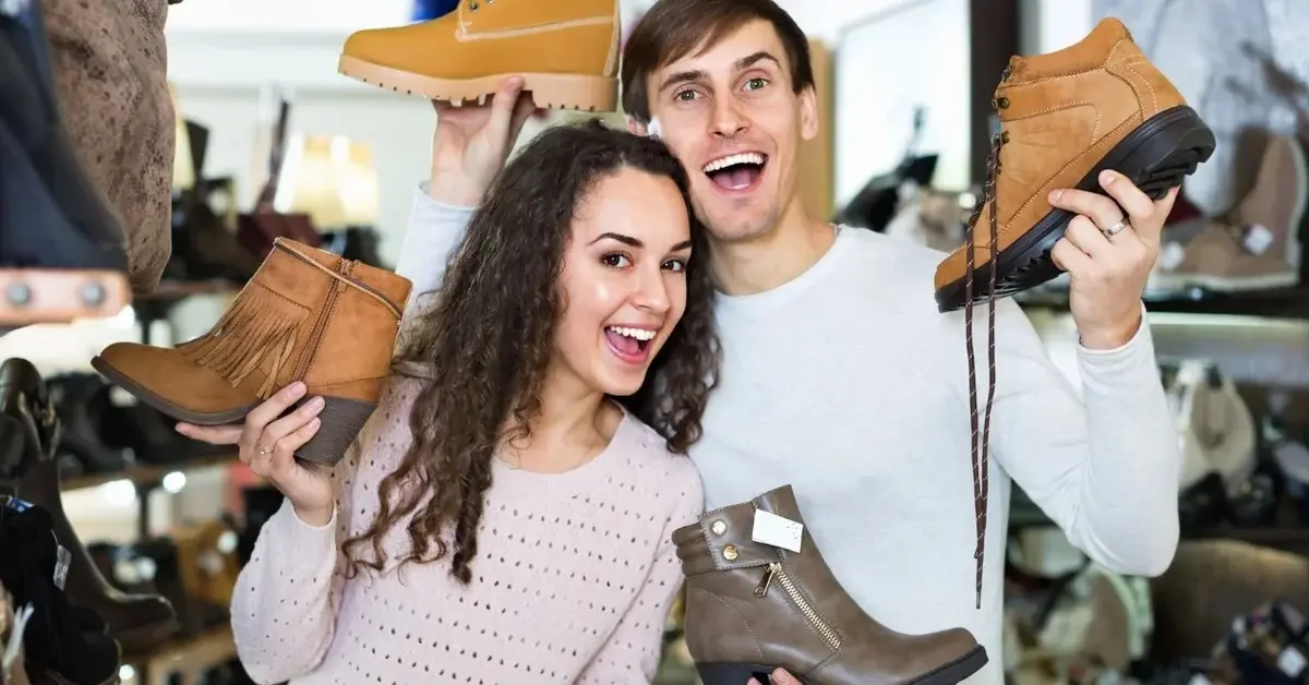 mężczyzna i kobieta trzymają różne jesienne buty w rękach i uśmiechają się