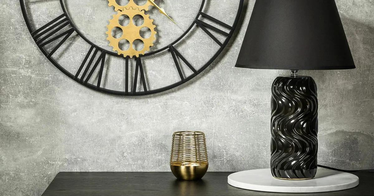 Konsola z czarną lampą stołową w eleganckim stylu na tle betonowej ściany