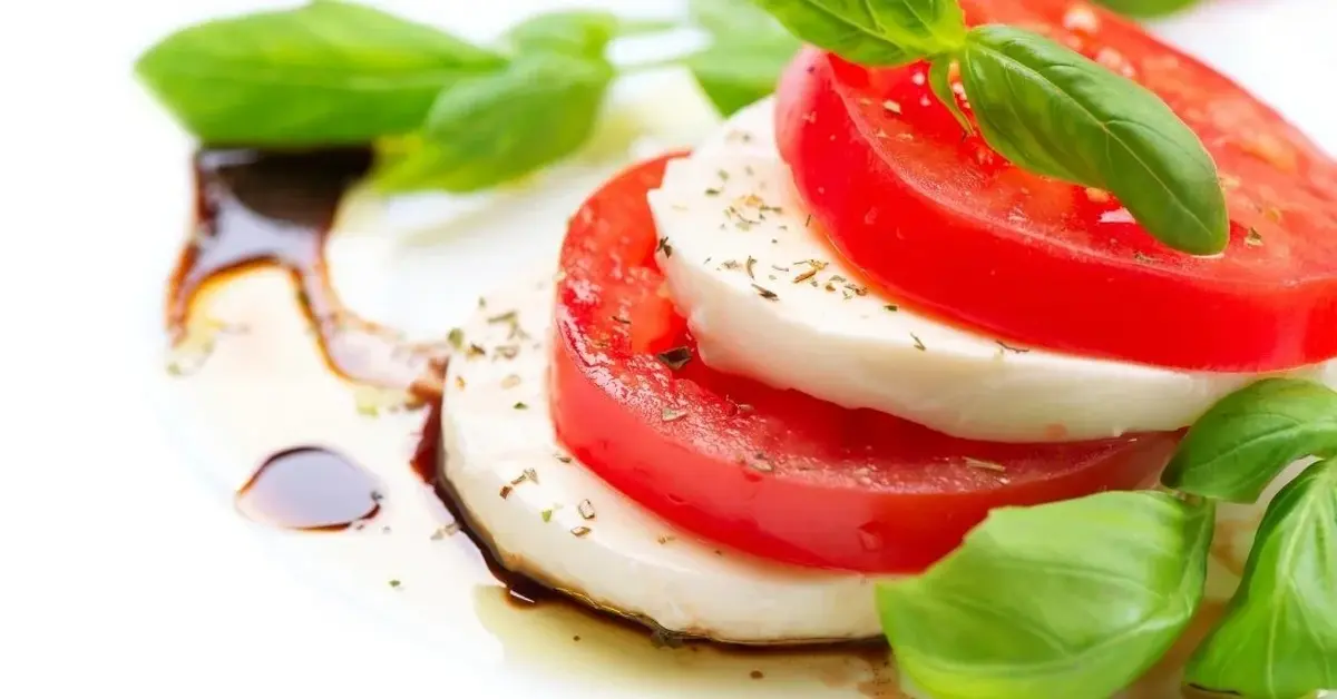 Sałatka caprese - pomidory, mozzarella, bazylia i ocet balsamiczny.