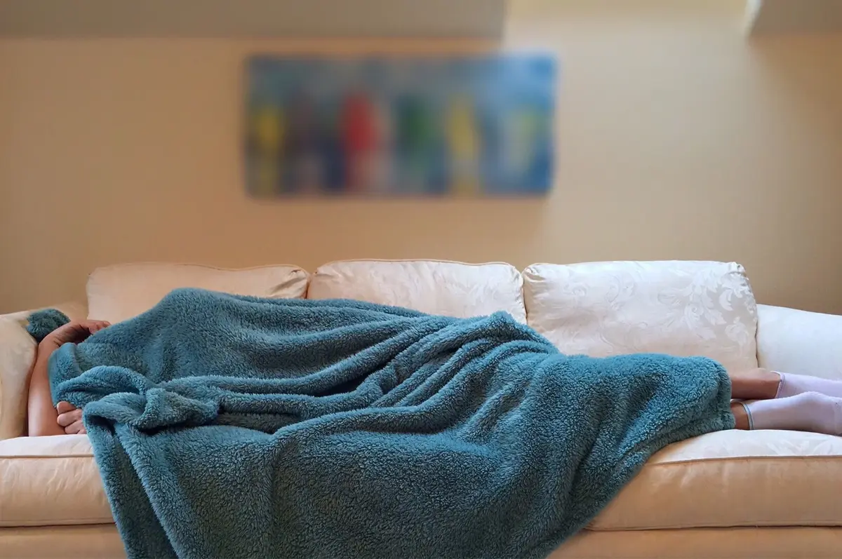 ktoś śpiący pod niebieskim ręcznikiem
