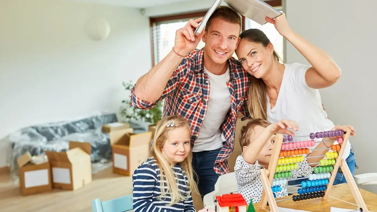 zabawy dla dzieci w domu rodzice trzymaja ksiazke nad sobą przy stole siedza dzieci z kolorowym liczydlem