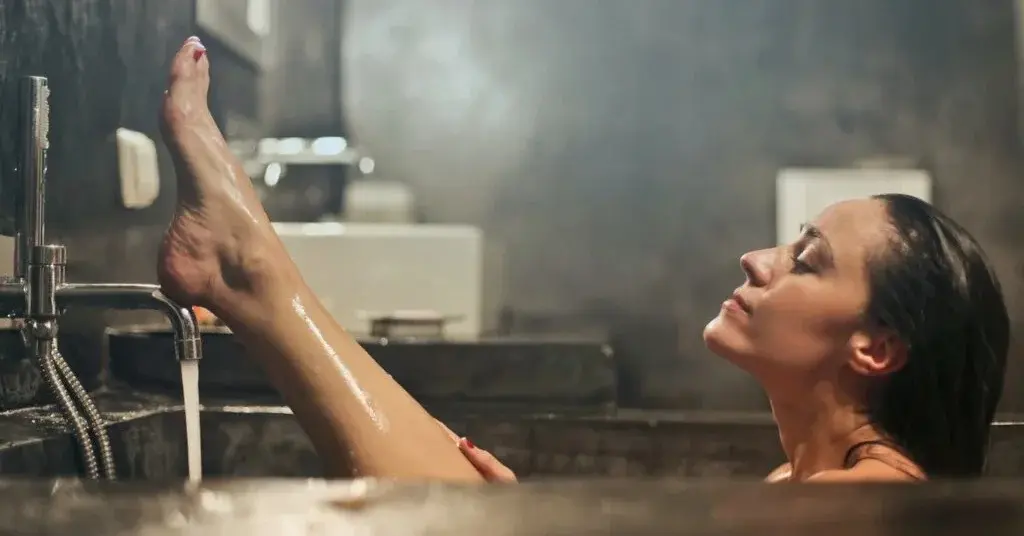 Kobieta w kąpieli w wannie z ekskluzywnymi kosmetykami