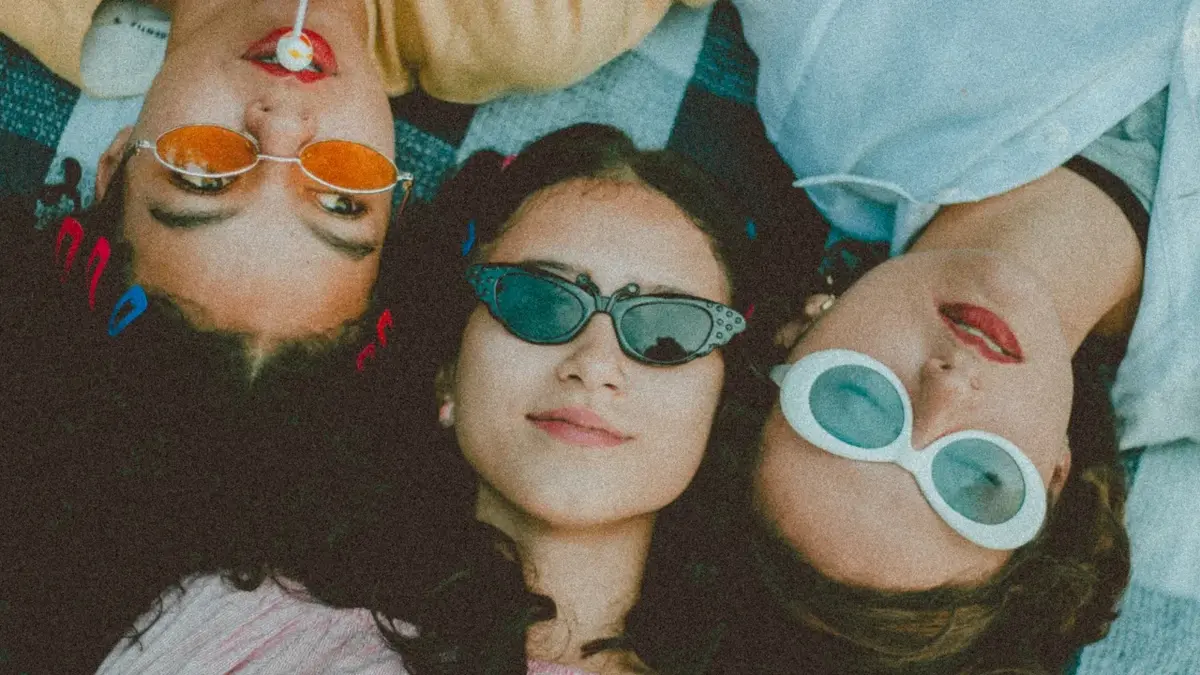 Okulary przeciwsłoneczne w różnych kolorach i kształtach na trzech kobietach