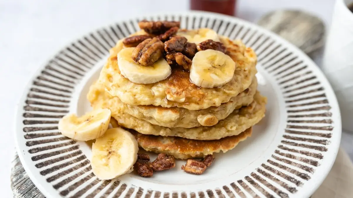 Protein pancakes z bananami i orzechami na talerzu 