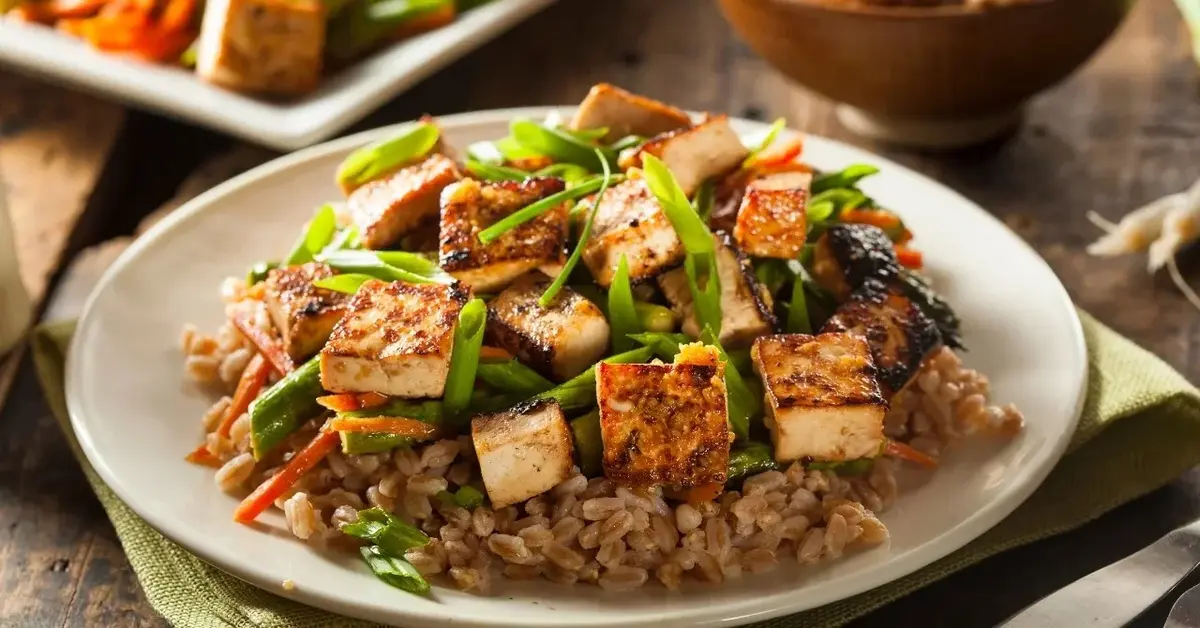 Tofu z warzywami i kaszą na talerzu 