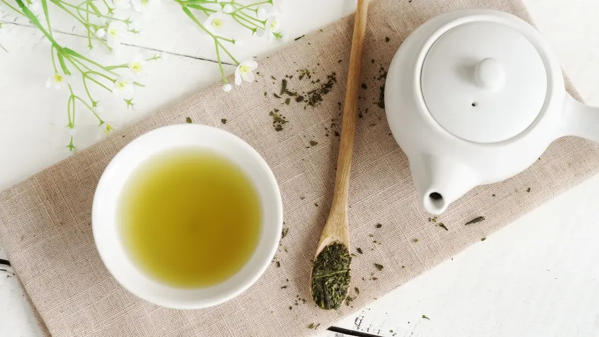 Zielona herbata w filiżance, obok dzbanuszek 