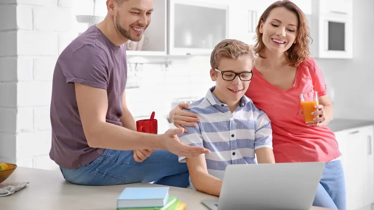 Chłopiec z rodzicami siedzący przy biurku z komputerem