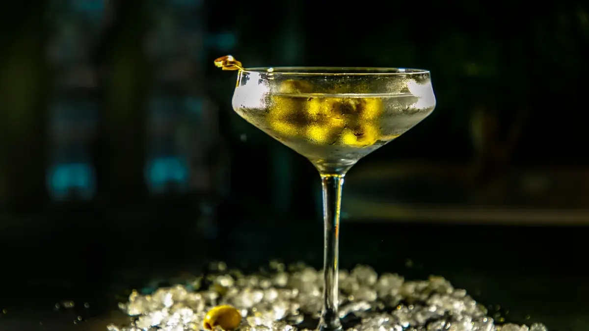 Drink z martini z oliwkami w wysokim kieliszku