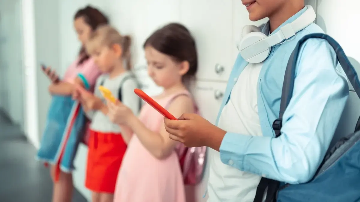 Dzieci na korytarzy szkolnym patrzące w telefony