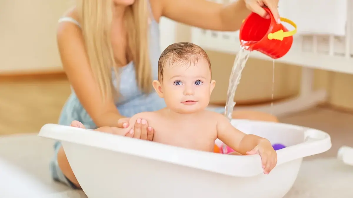niemowle kąpane w wanience przez mamę