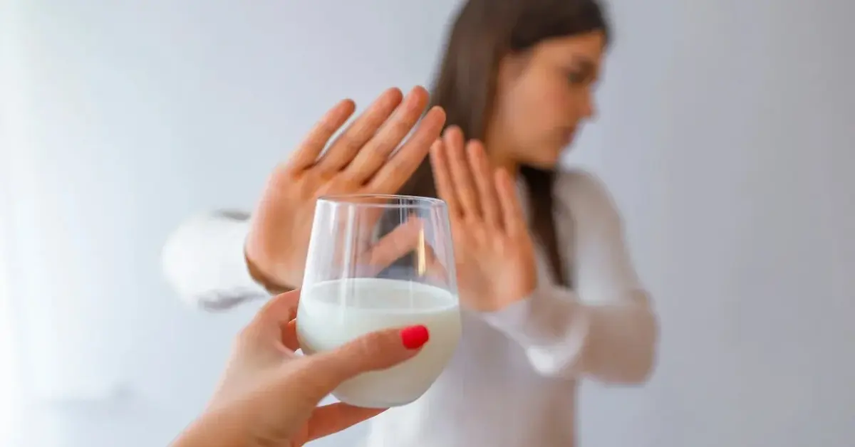 kobieta odsuwająca od siebie szklanke mleka 