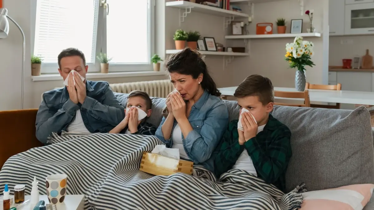 Rodzina w łóżku pod kołdrą chora na grypę