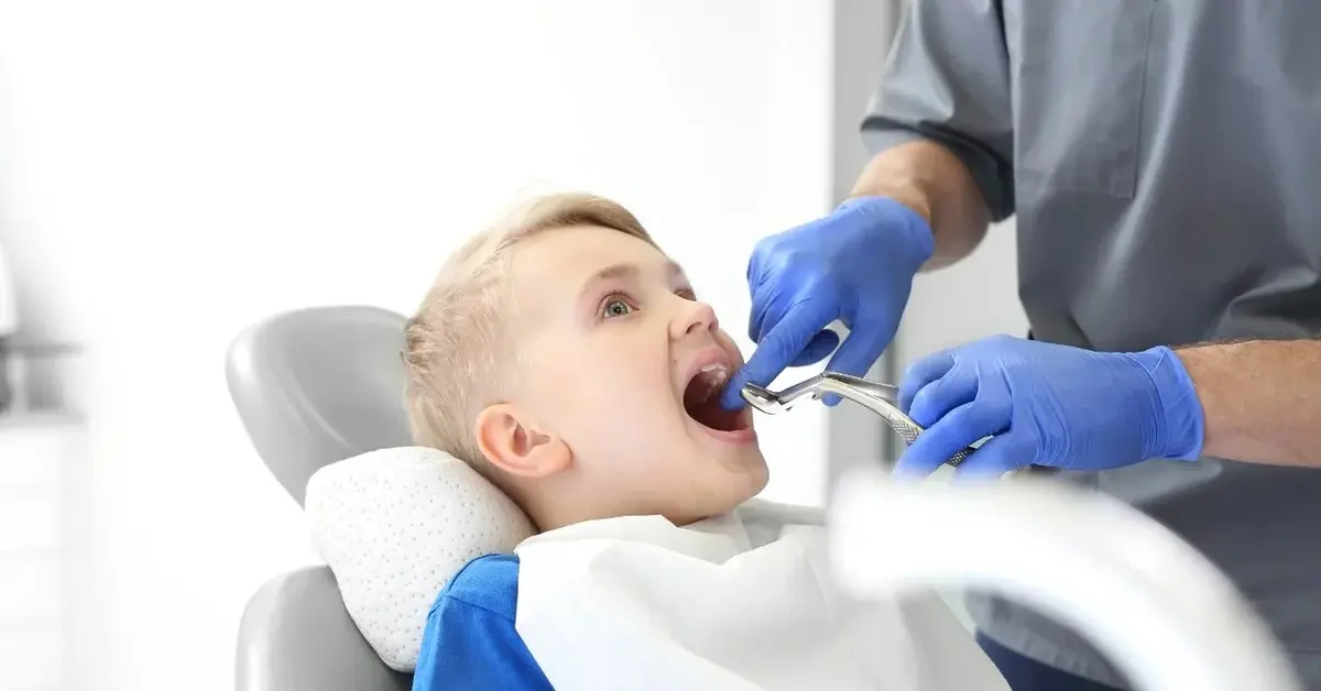 dentysta wyrywa ząb chłopcu