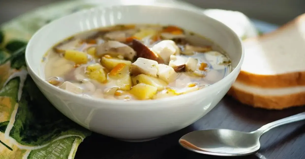 Jesienna zupa z leśnych grzybów z ziemniakami w białej miseczce