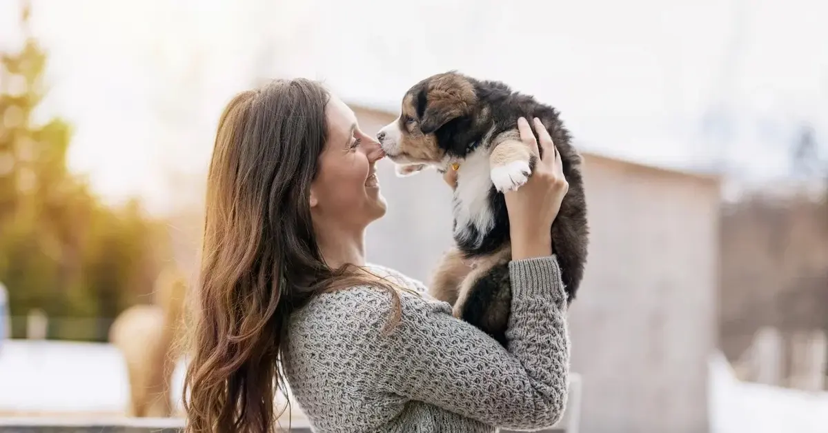 Kobieta trzymająca szczeniaczka na rekach