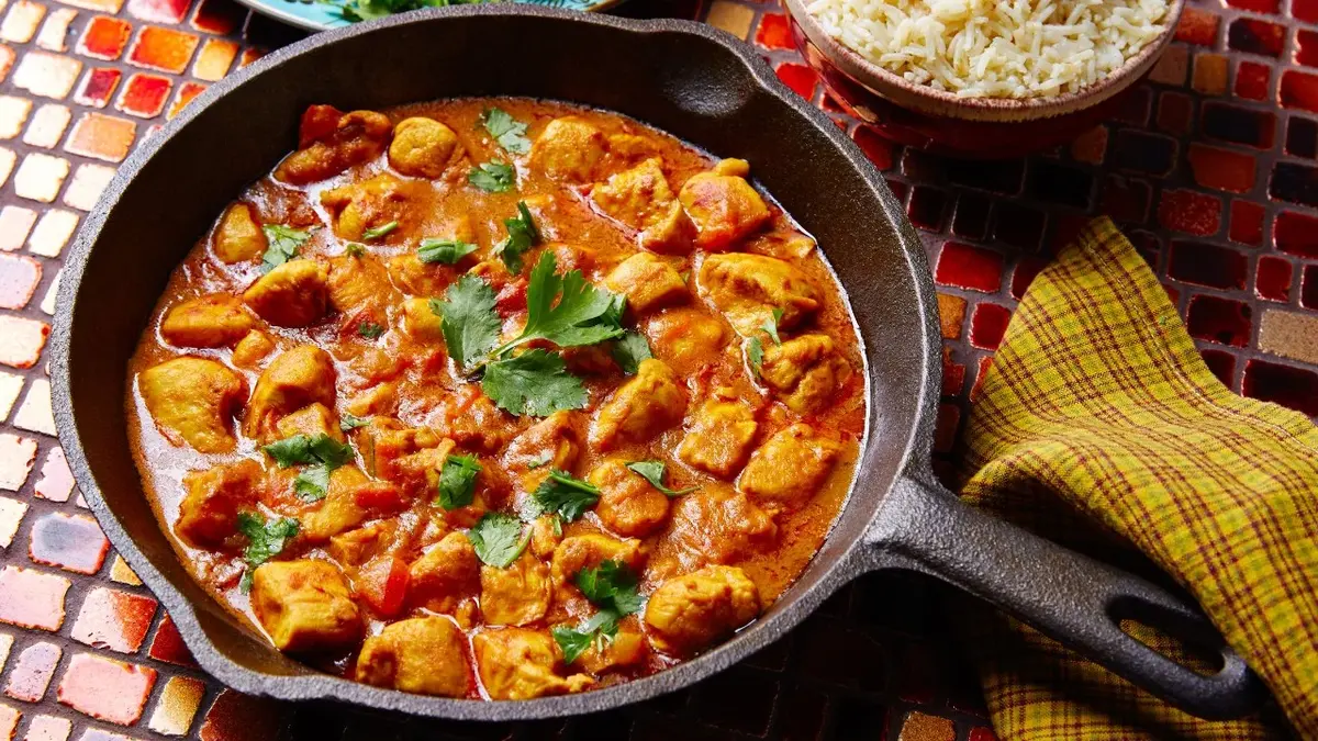 kurczak curry na patelni z natką pietruszki w tle ściereczka ryż 