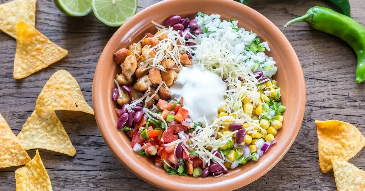 bowl meksykańskie kukurydza ryż papryka cebula wokół miski nachosy limonki i zielona papryczka