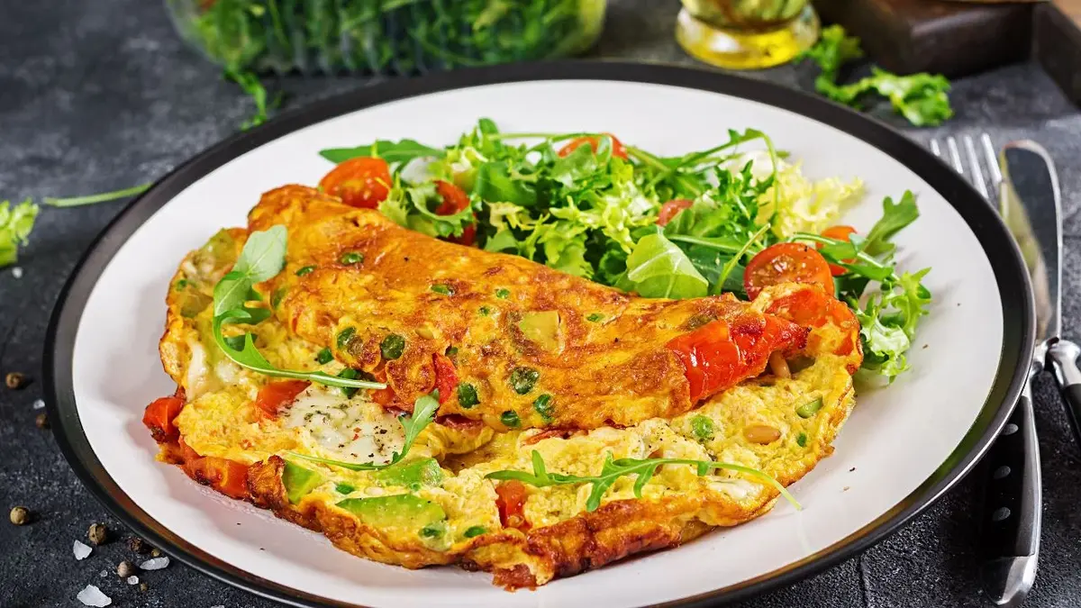 Omlet podany z zieloną sałatą oraz pomidorkami