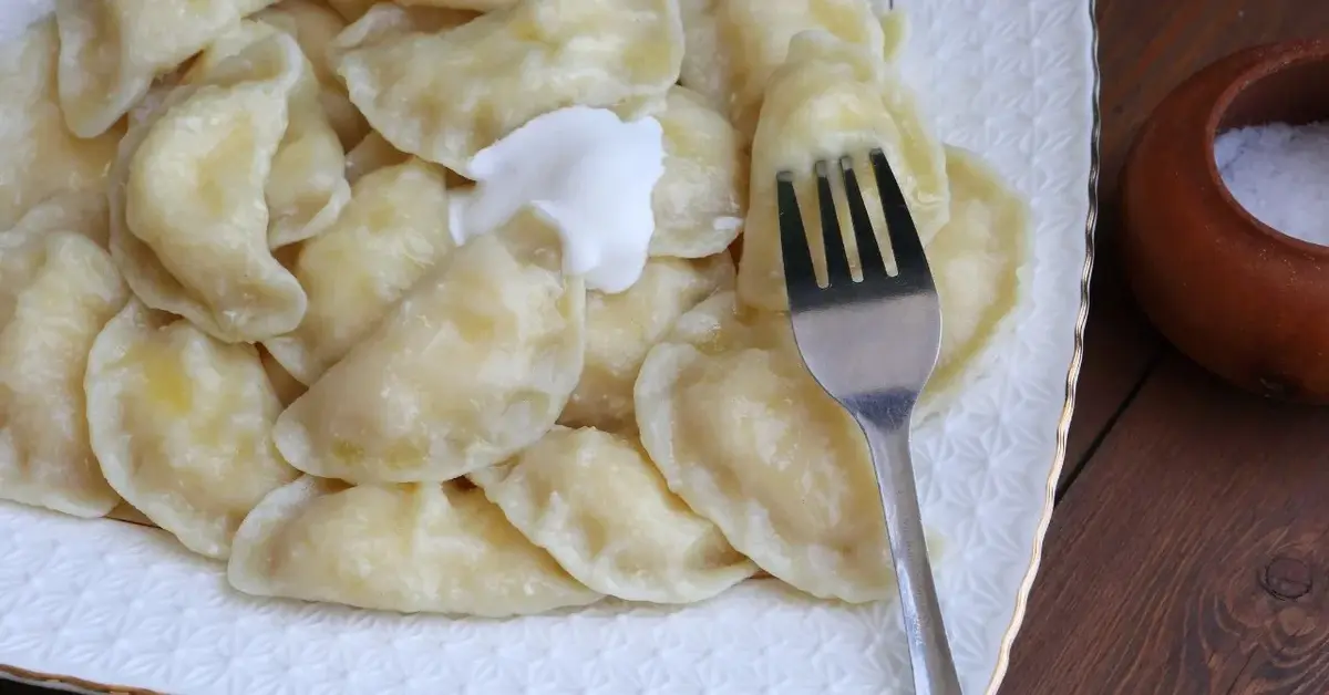 pierogi z serem widelec talerz śmietana