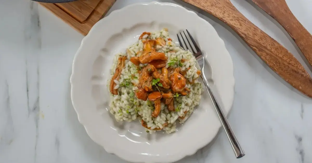 risotto z kurkami na talerzu w tle drewniane łyżki