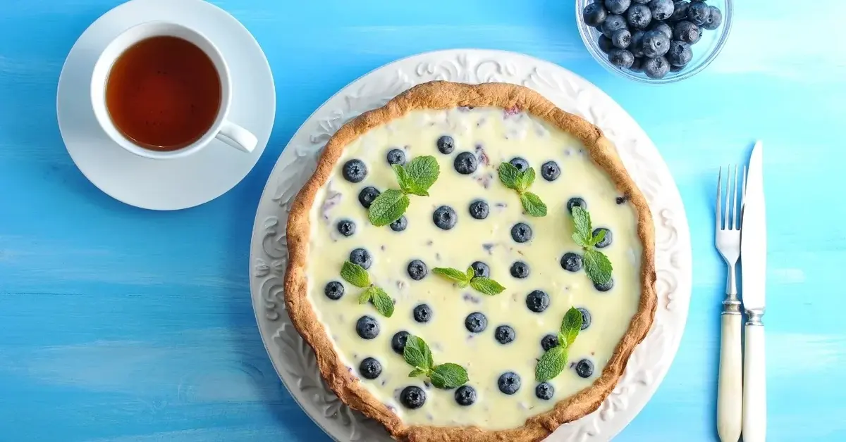 Tarta z białą czekoladą i borówkami na niebieskim tle