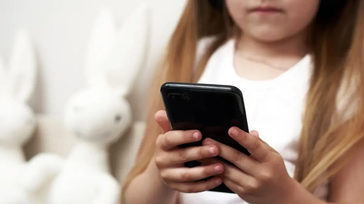 Dziewczynka trzymająca w ręce telefon