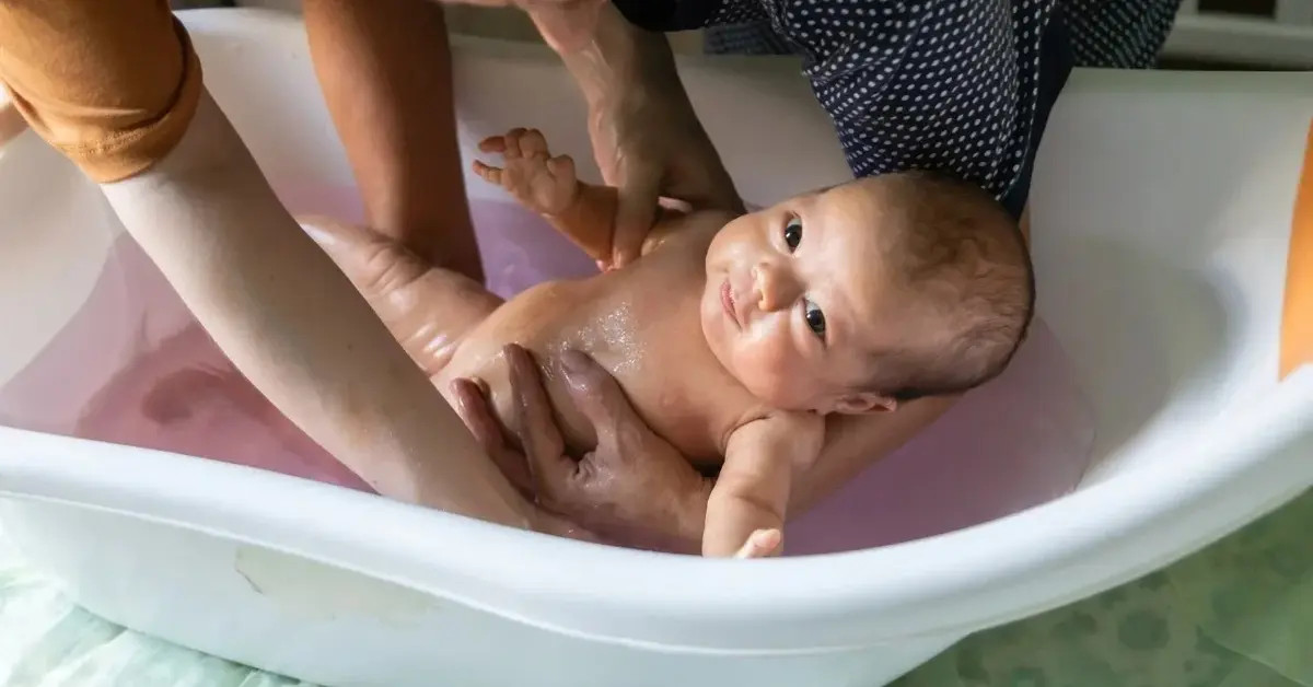 Niemowle w wanience kąpane przez rodziców