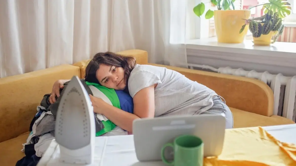 Zmęczona macierzyństwem mama leży na kanapie.