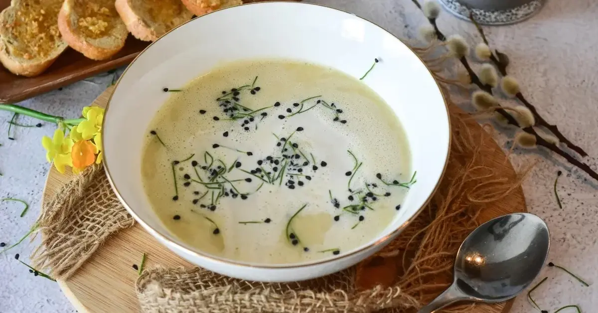 zupa w misce w tle kromki chleba bazie żonkil łyżka podkładka drewniana