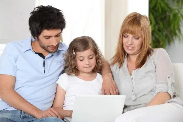 Dziecko z rodzicami przed komputerem