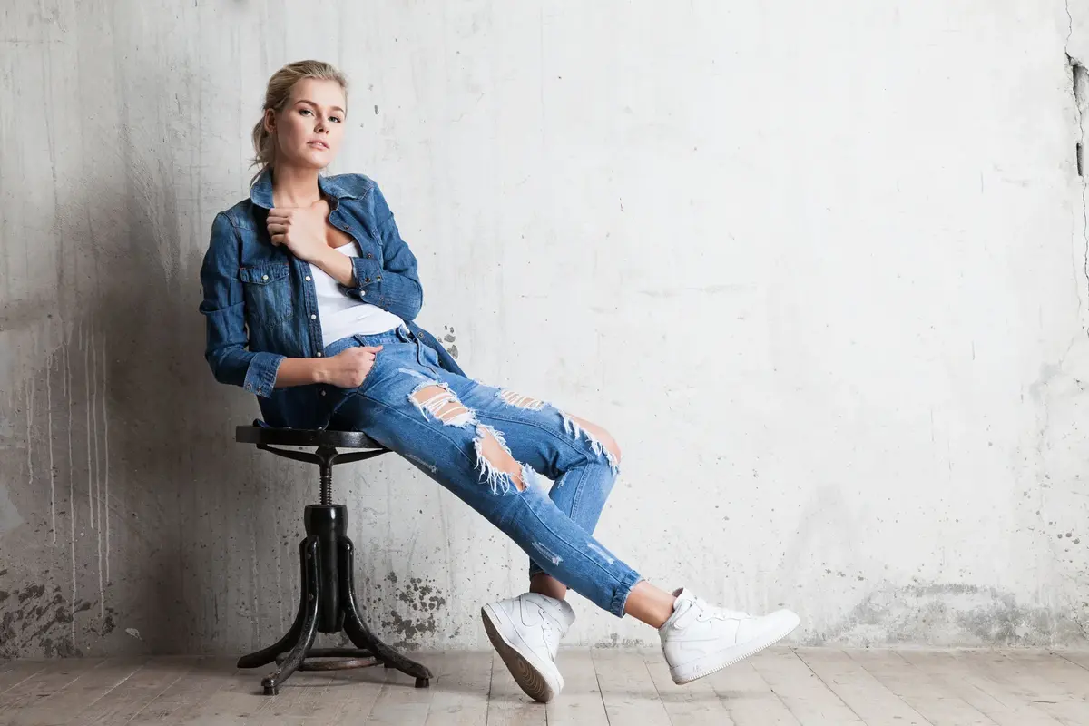 Woman in jeans sitting on wooden chair
