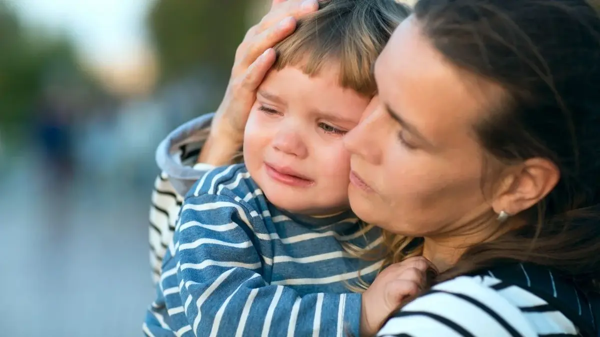 płaczące dziecko w ramionach matki