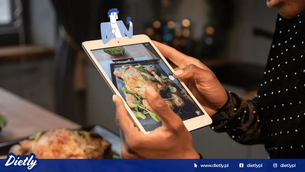 Osoba trzyma w dłoniach tablet ze zdjęciem przedstawiającym jedzenie