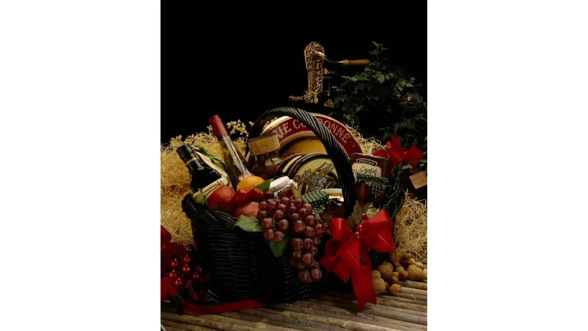 Świąteczny kosz z winem, serem i owocami.