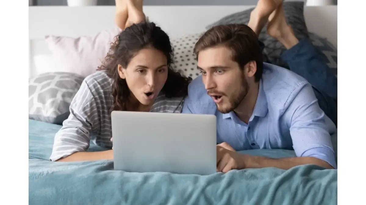 Zaskoczona para patrzy na ekran laptopa