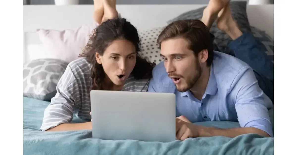 Zaskoczona para patrzy na ekran laptopa