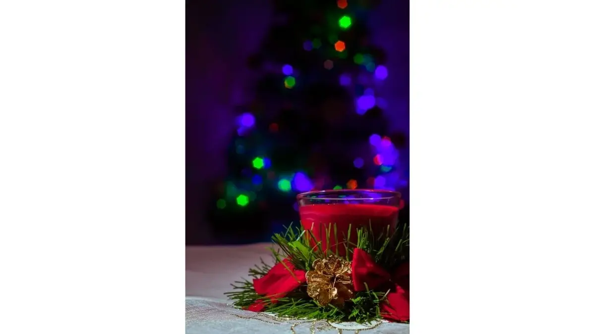 Czerwona świeczka i skromy, świąteczny stroik z szyszką