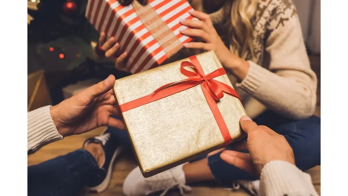 Widać ręce osób wymieniających się prezentami.