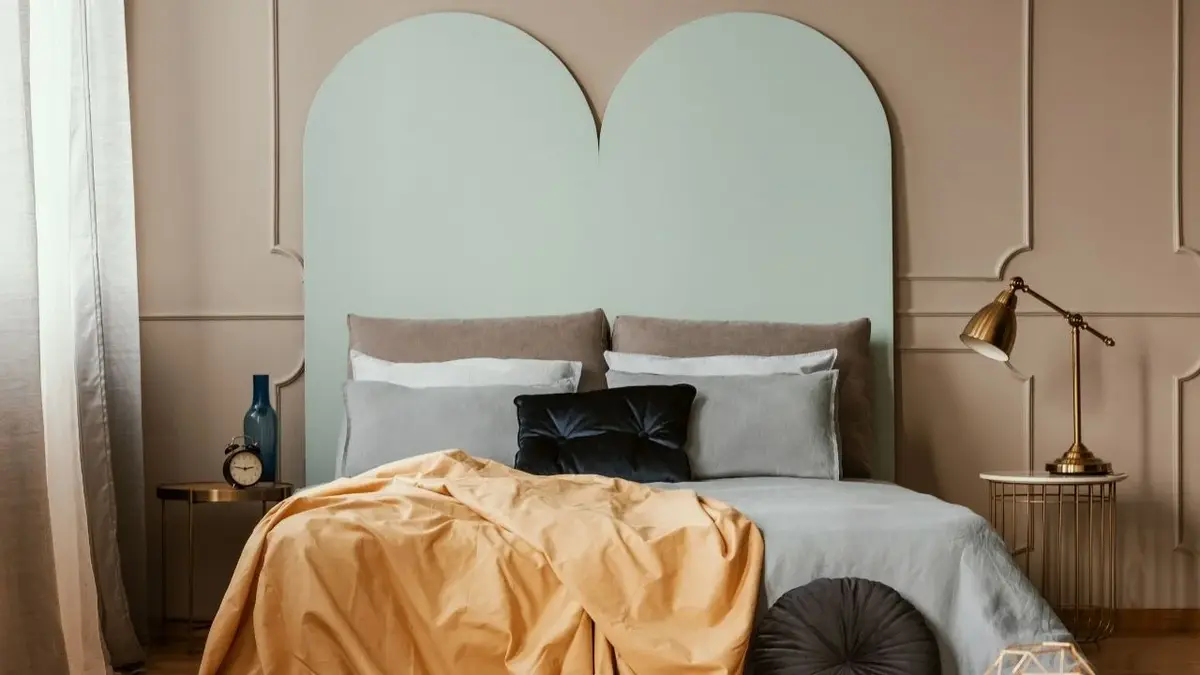 Łóżko z szaroniebieskim geometrycznym zagłówkiem na ścianie