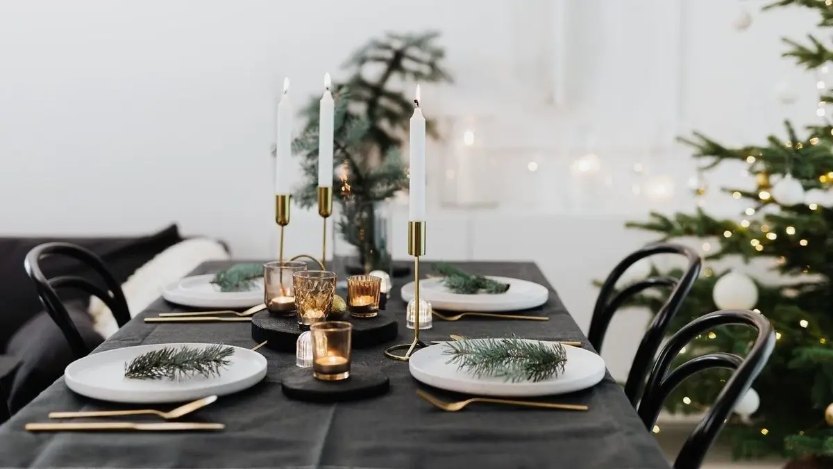 Białe talerze na świątecznym stole przykrytym czarnym obrusem